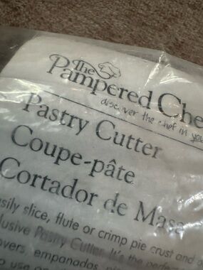The Pampered Chef Pastry Cutter Packaging - White and Black Text